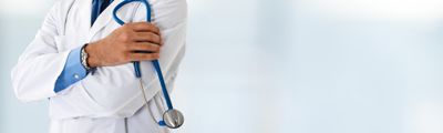 A doctor in a white coat, his arms crossed, holding a stethoscope.