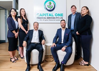 A group photo of the Capital One Financial Services team, all smiling and looking at the camera